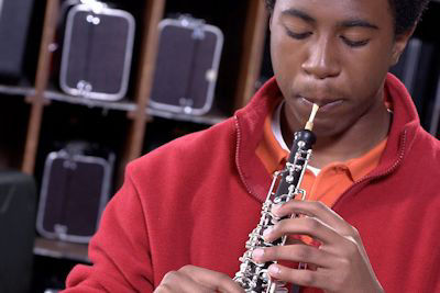 Student playing oboe in classroom; rent oboes here.